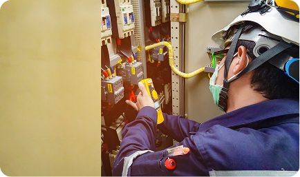 A man in a safety helmet is diligently working on a circuit board